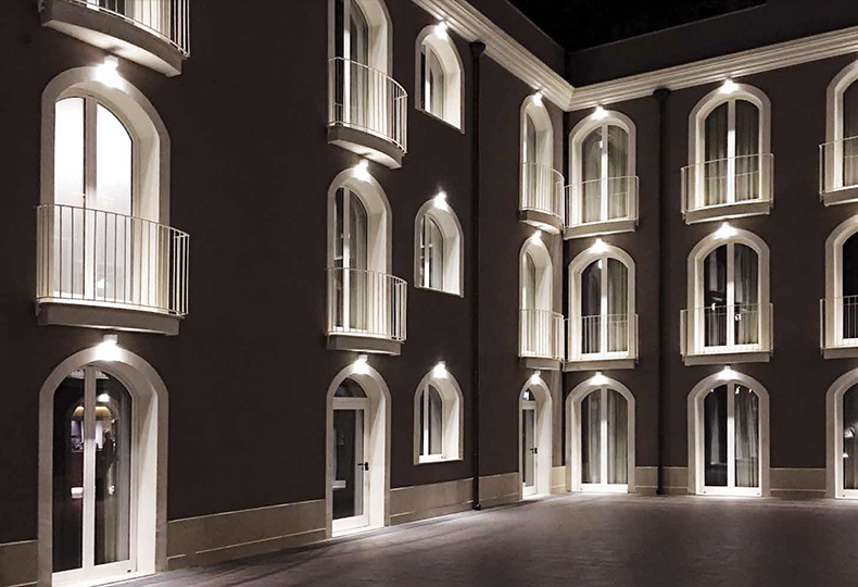 Фасад частной резиденции. Окна и двери подсвечены по вертикали настенными светильниками Nobile Italia SpA.