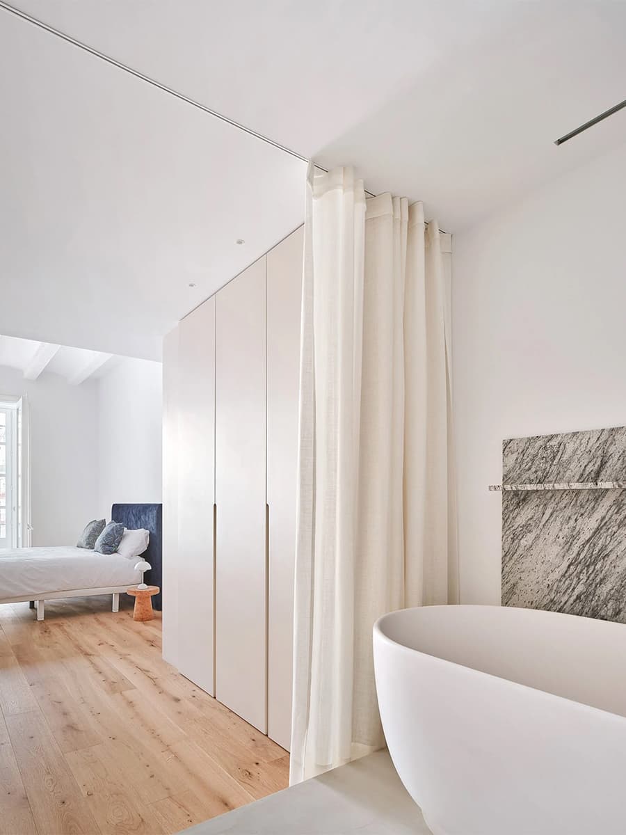 Светлый интерьер квартиры с акцентной стеной из орехового дерева — проект студии Raúl Sánchez Architects