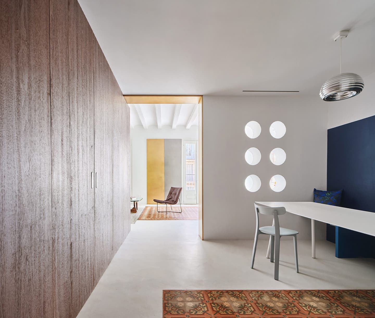 Светлый интерьер квартиры с акцентной стеной из орехового дерева — проект студии Raúl Sánchez Architects