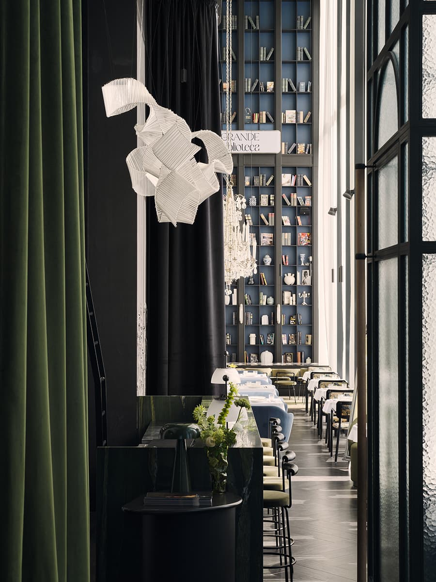 Многоярусные люстры и изящные книжные шкафы в интерьере ресторана — проект Алины Цауня
